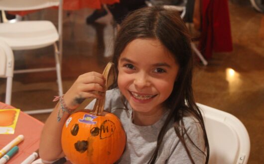 boo-springs-girl-holding-decorated-pumpkin